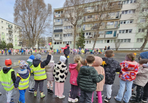 Dzieci stoją w dużym kole i śpiewają piosenkę na powitanie wiosny.