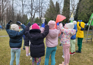 Dzieci w jednorazowych rękawiczkach, trzymając worki pozują do zdjęcia