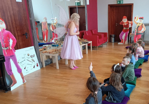Pani przebrana za wróżkę opowiada dzieciom o instrumentach