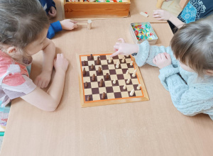 Dzieci grają w warcaby.