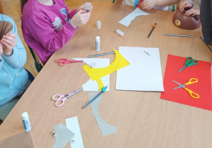 Dzieci wycinają i kleją ozdoby z papieru