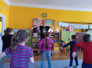 Dzieci naśladują ruchy instruktorki tańca.