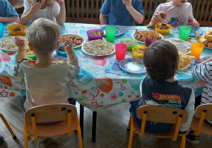 Dzieci jedzą poczęstunek przygotowany przez rodziców