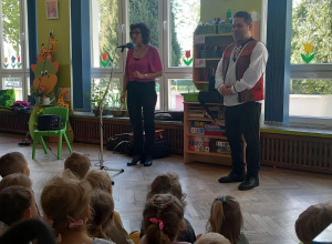 Pan i Pani stoją przed dziećmi i opowiadają im o utworach muzycznych