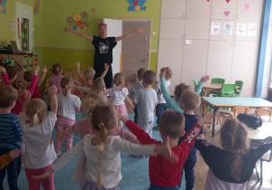 Dzieci naśladują ruchy prowadzącej i podnoszą ręce do góry