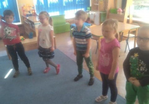Dzieci w kole śpiewają hymn przedszkolaka