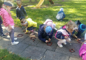 Dzieci bawią się kasztanami na dworze