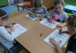 Dzieci malują mazakami po obrazkach dłoni