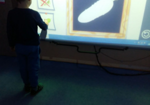 Chłopiec szuka odpowiedniego cienia na tablicy interaktywnej