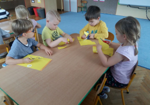 Dzieci ćwiczą wycinanie przy stoliku