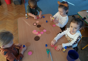 Dzieci przy stoliku wykonują pracę techniczną - misiowe uszy
