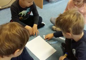 Grupa dzieci układa misiowe puzzle