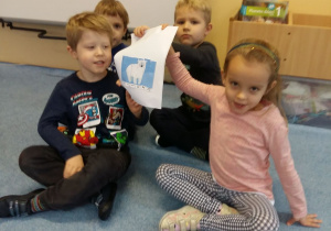 Dzieci pokazują ułożony obrazek misia