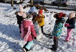 Dzieci tańczą w ogrodzie przedszkolnym przy bałwanku