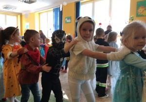 Dzieci tańczą na balu trzymając się za ramiona