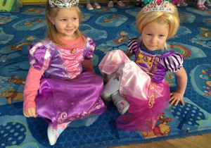Dwie księżniczki siedzą na dywanie
