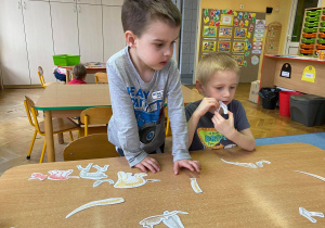 Dzieci układają sylwety dinozaurów