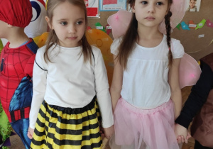 dwie dziewczynki stoją w kole przebrane sa za pszczółkę oraz motylka