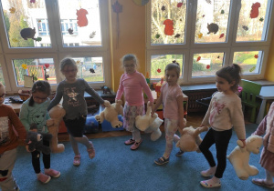 Dzieci tańczą trzymając maskotki za łapki